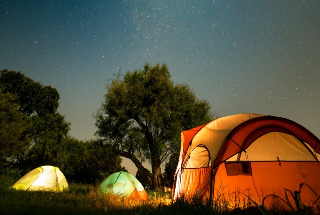 Nuit paisible au camping avec des tentes éclairées sous un ciel nocturne
