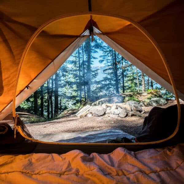 Tente campée au bord d'un lac entouré de montagnes