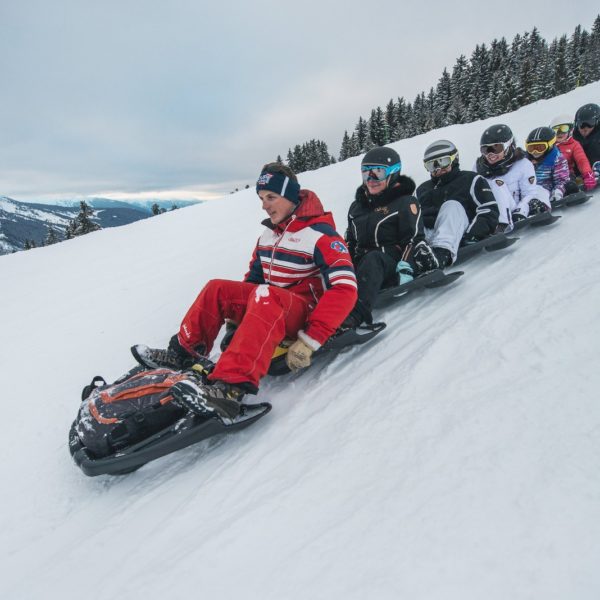 Luge sur neige à la montagne en groupe