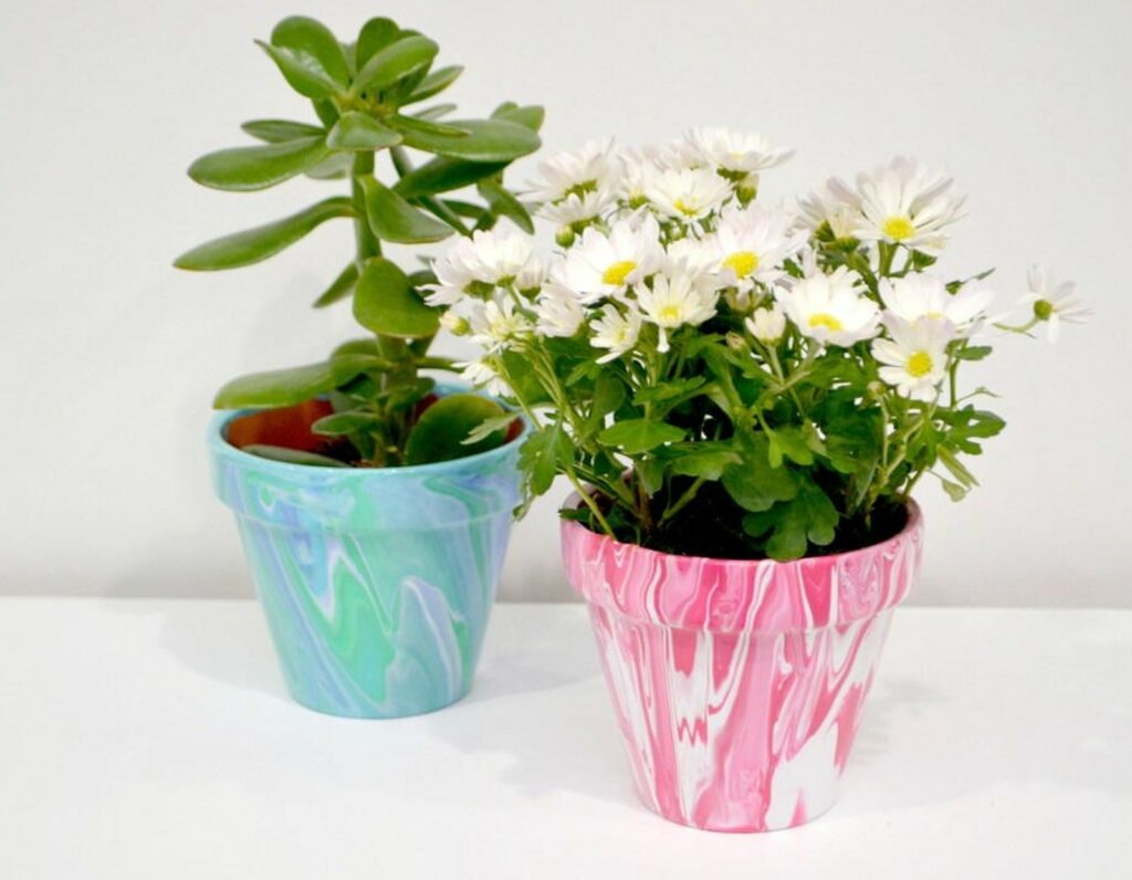 2 pots en terre cuite personnalisés, chacun avec un style différent créé par la technique de versement de peinture