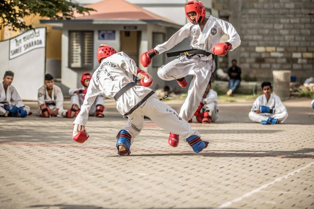 Groupe de jeunes pratiquants de taekwondo effectuant un exercice de coups de pied en l'air