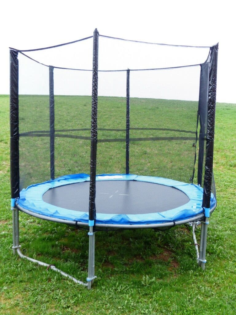 Trampoline sécurisé avec vue sur la campagne, offrant un paysage pittoresque en toile de fond