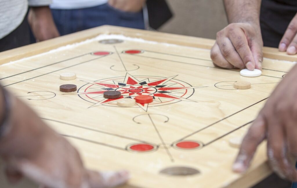 Palet en mouvement sur la planche de carrom, illustrant l'énergie et l'excitation du jeu