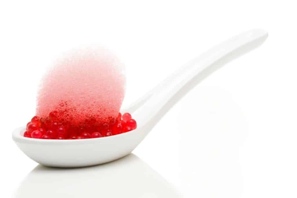 Des perles gélifiées aux saveurs intenses sur une cuillière élégante