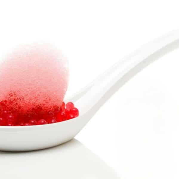 Des perles gélifiées aux saveurs intenses sur une cuillière élégante