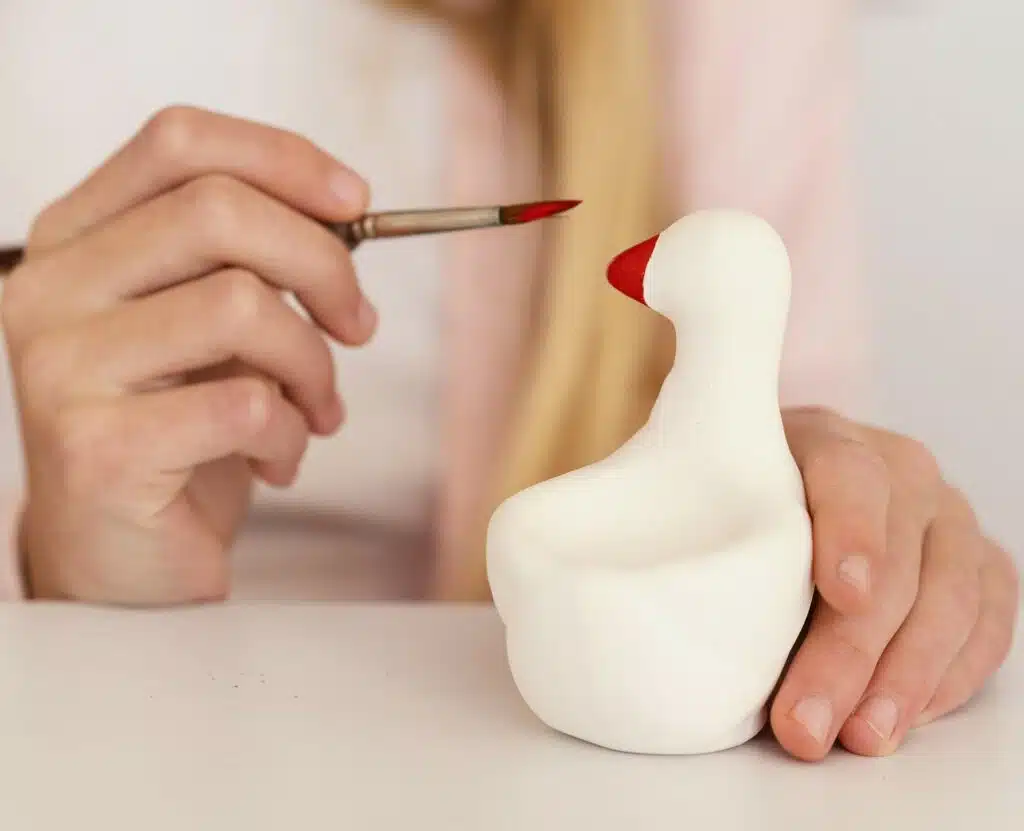 Enfant qui peint une figurine en pâte à sel