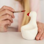 Enfant qui peint une figurine en pâte à sel