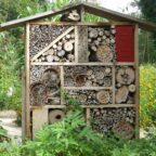Hôtel à insectes installé dans un jardin fleuri