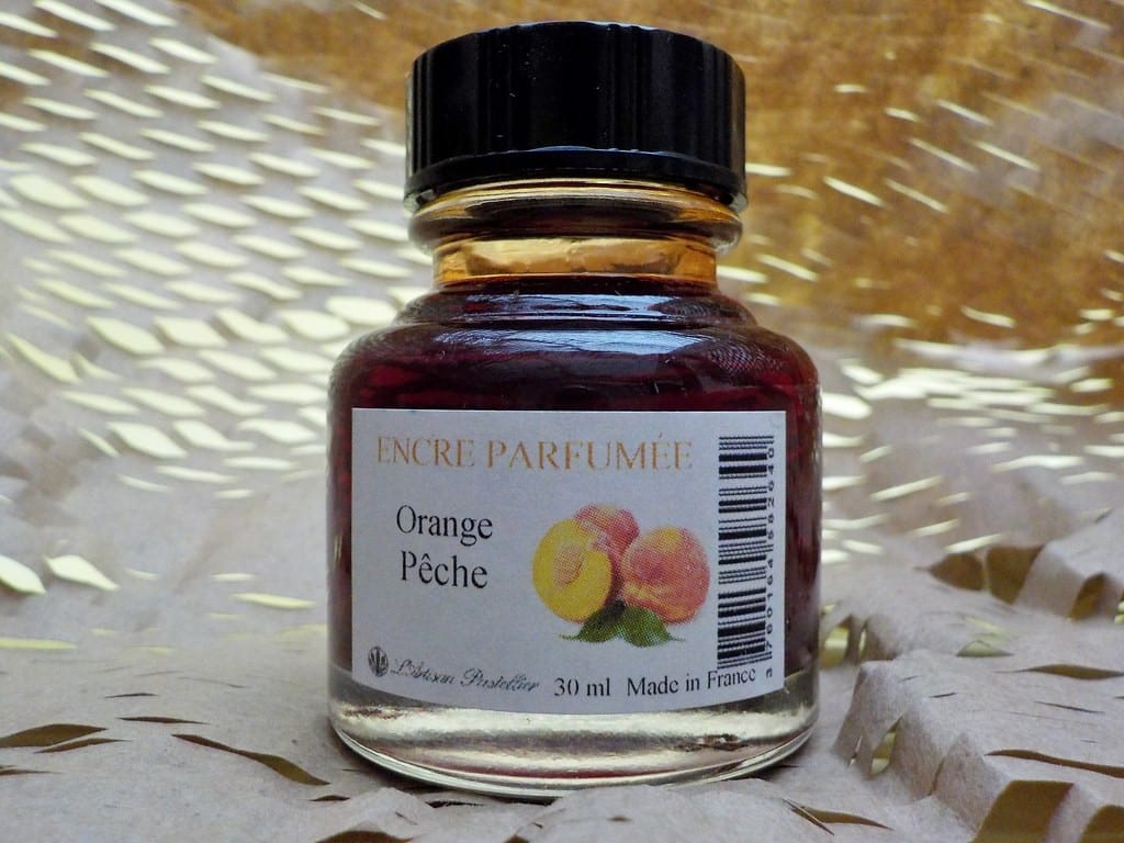 Flacon d’encre parfumée posé sur un bureau élégant