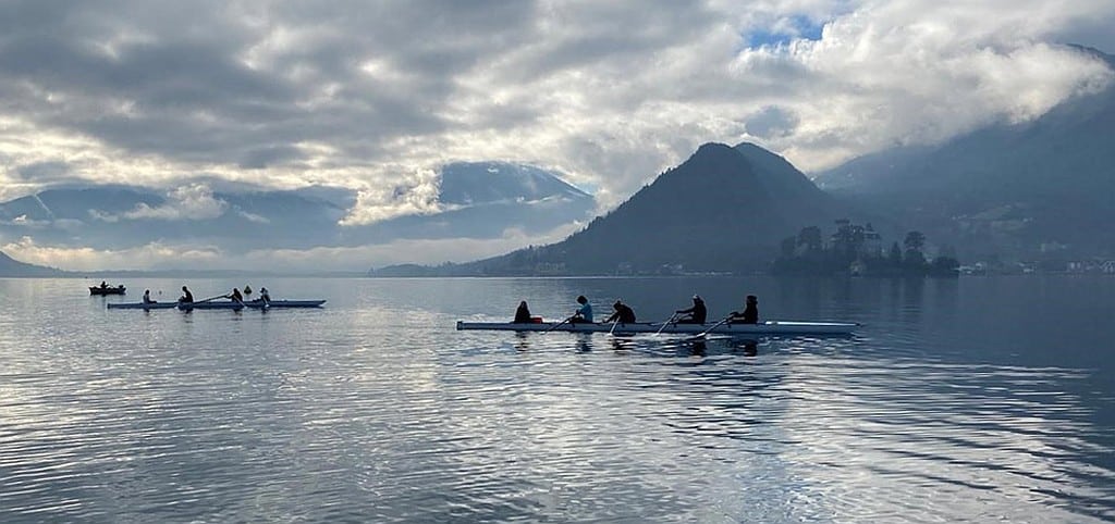 Aviron sur un lac calme avec des rameurs concentrés
