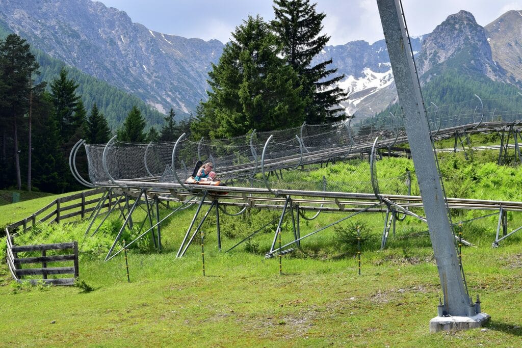 Famille profitant d’une descente en Mountain Luge, activité ludique et accessible en montagne