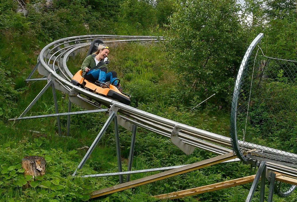 Pratiquant dévalant une piste de Mountain Luge en été, alliant vitesse et sensations de glisse