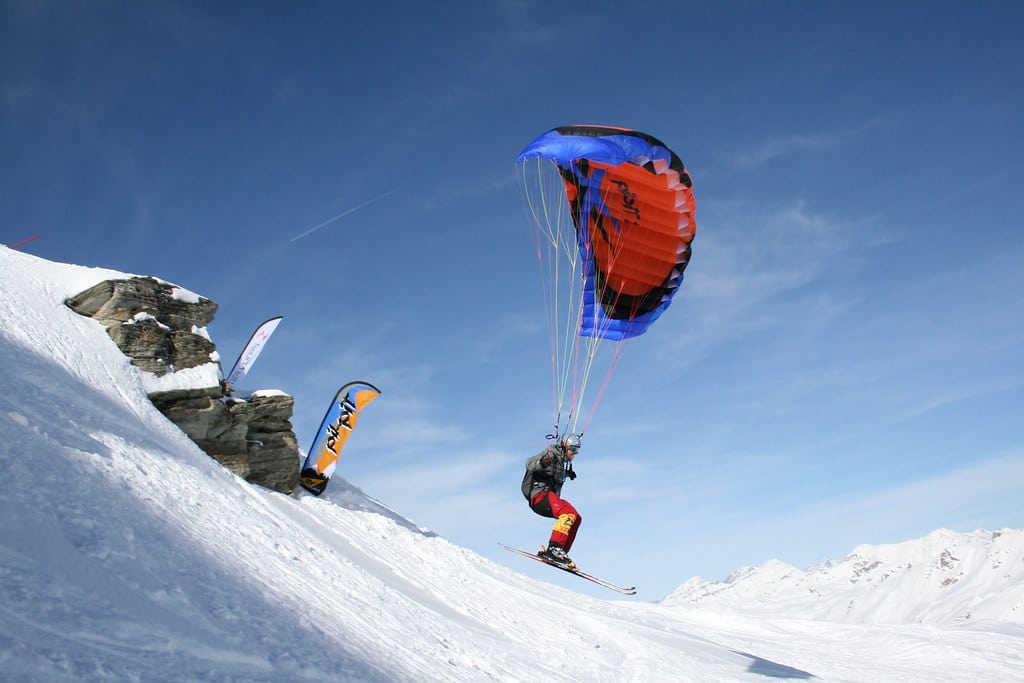 Speedflyer dévalant une pente à grande vitesse avec une mini‑voile, fusionnant vol et glisse