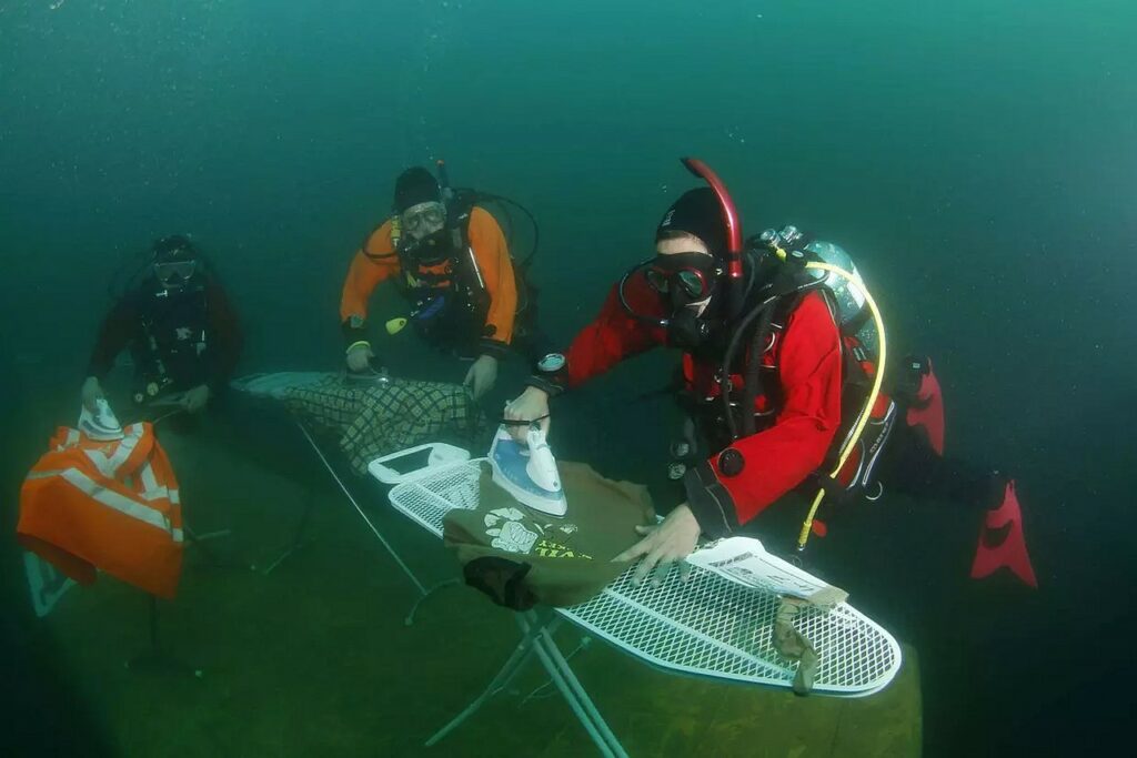Plongeurs effectuant du repassage extrême sous l'eau, planche fixée au fond marin